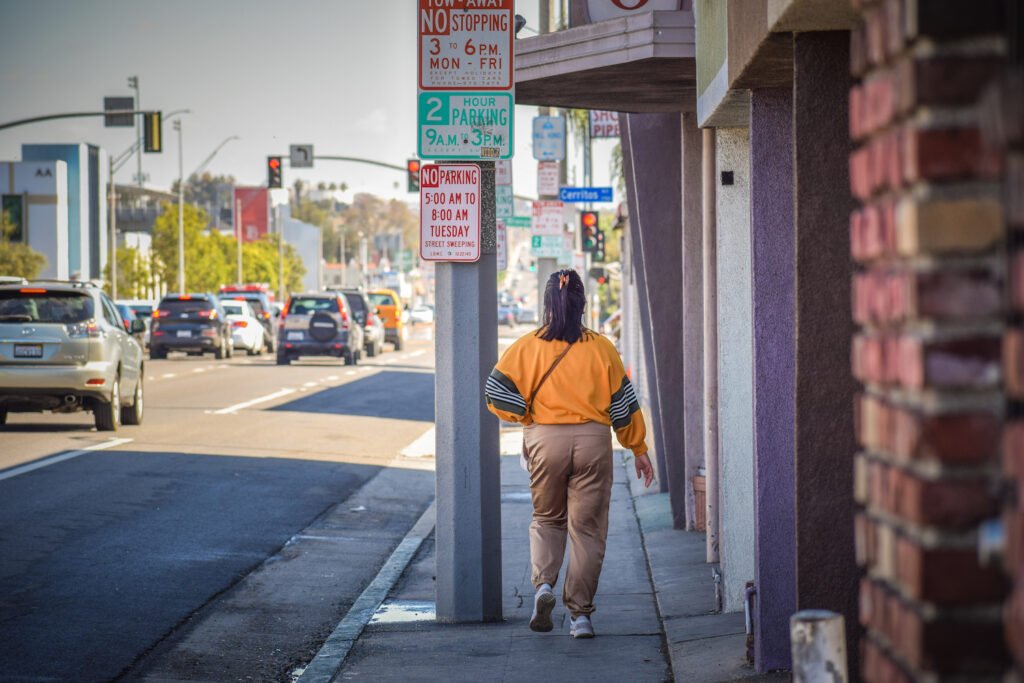 A denizen of the Sixth District walks easterly on Pacific Coast Highway, an area that has been home to historic Black businesses, including VIP Records. Photo by Brian Addison.