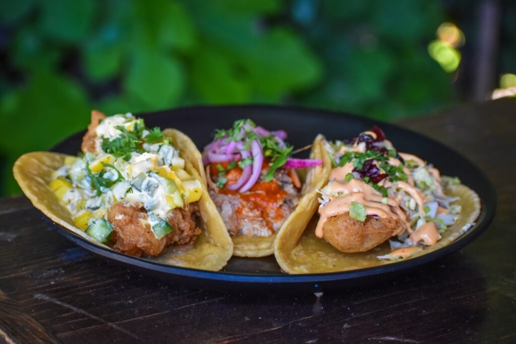 A trio of tacos from Padre: Fried chicken [left], carnitas [center], and Baja-style fish [right]. Photo by Brian Addison.
