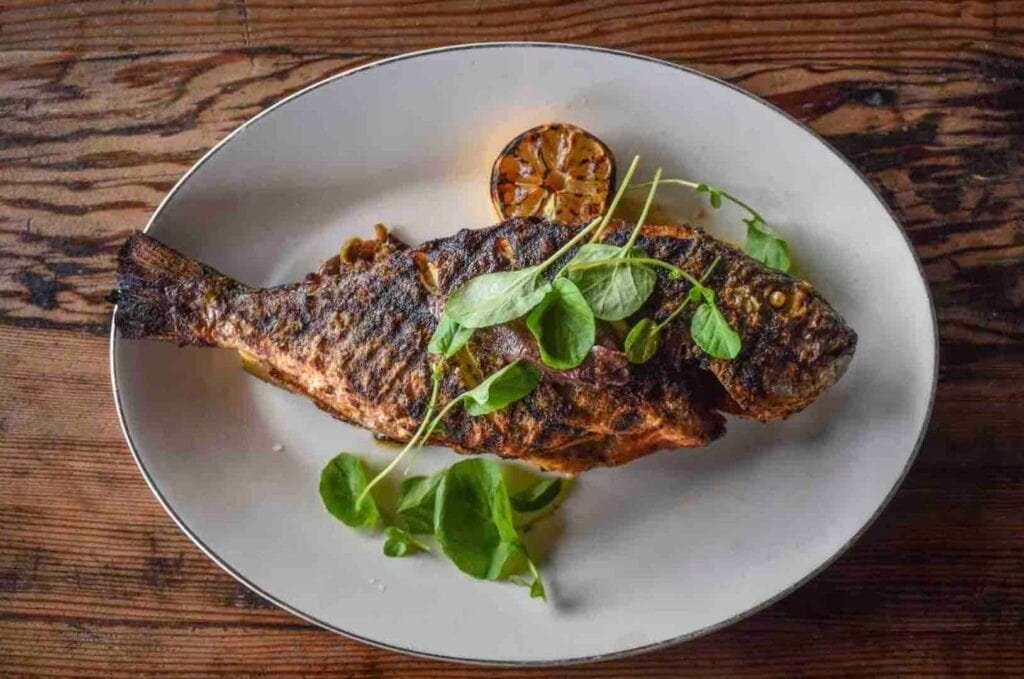 The wood fire-grilled whole dorade with Sicilian caponata and olive tapenade from Wood & Salt. Photo by Brian Addison.