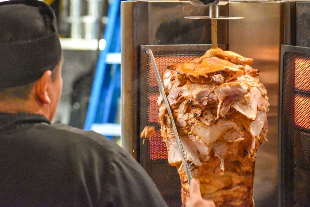 A cook at Open Sesame in Belmont Shore carves chicken shawarma. Photo by Brian Addison.