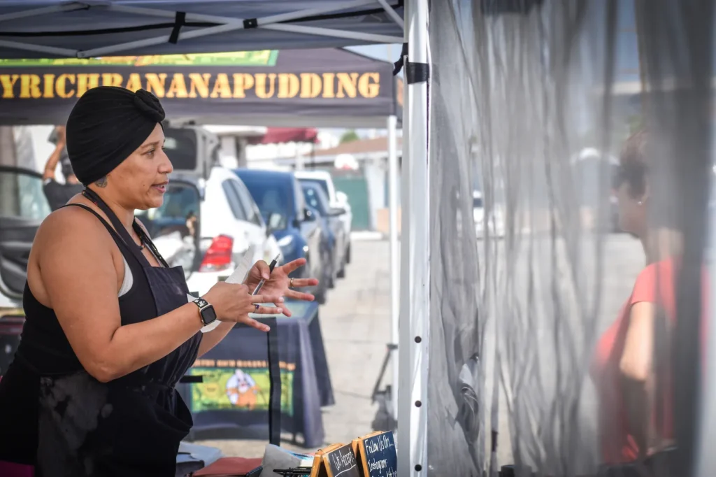 Qiana Mafnas, owner of Axiom, serves a customer at their popup. Photo by Brian Addison.